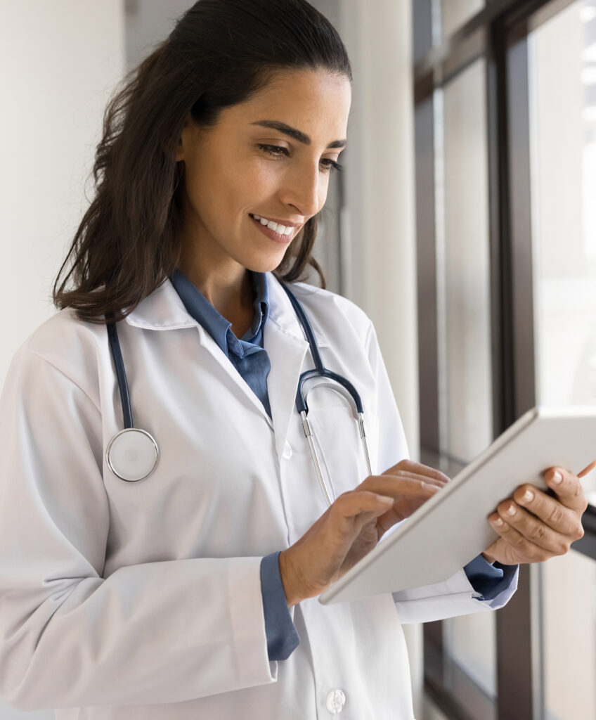 A doctor studying what's on their tablet device.